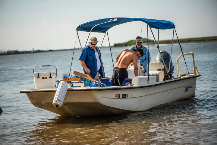 Captain John with a few passengers pulling up to shore