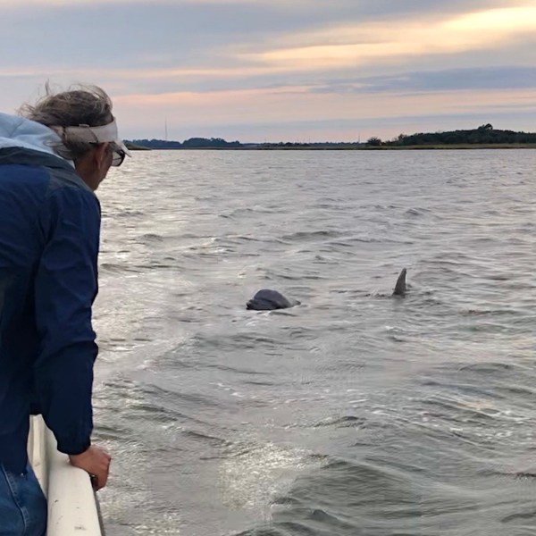 a man standing next to a body of water