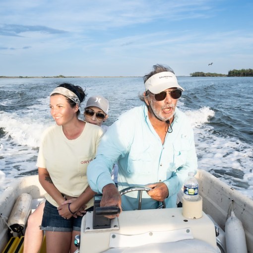 a man and a woman sitting on a boat in the water
