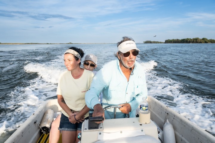 a man and a woman sitting on a boat in the water