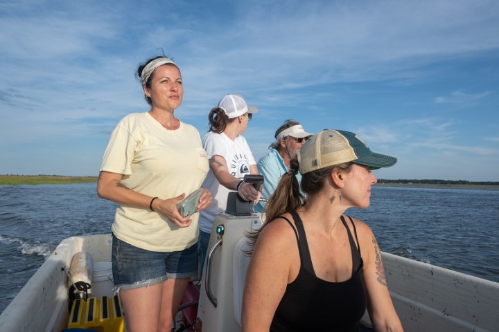 a woman standing next to a body of water